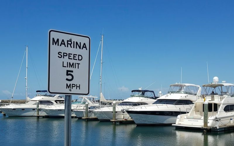 Panneau de limitation de vitesse dans la marina avec bateaux amarrés
